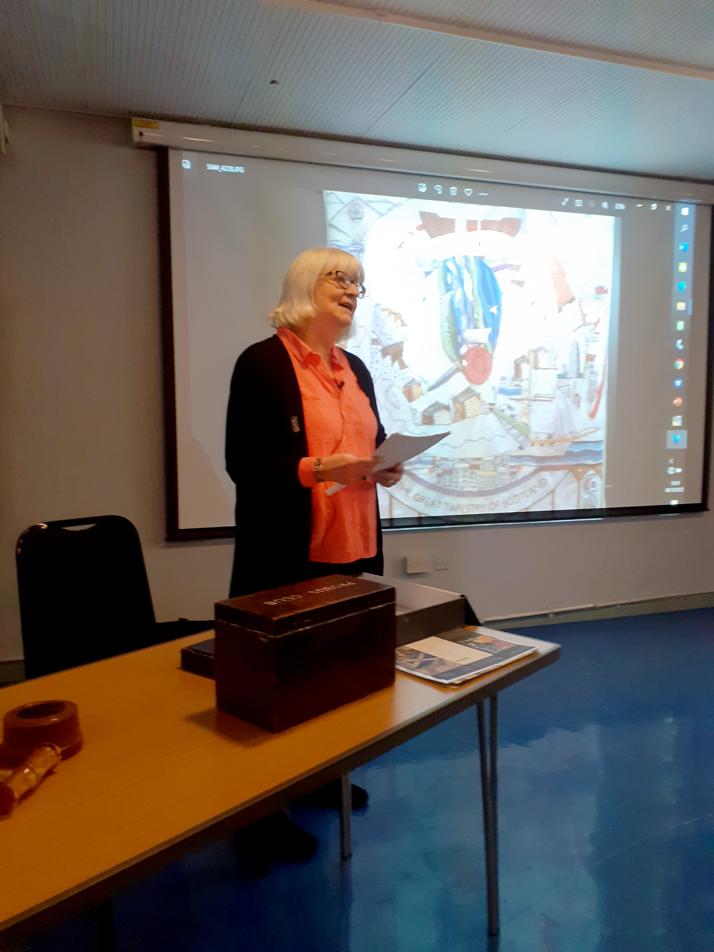 photo pf Ann standing up doing a presentation of her work