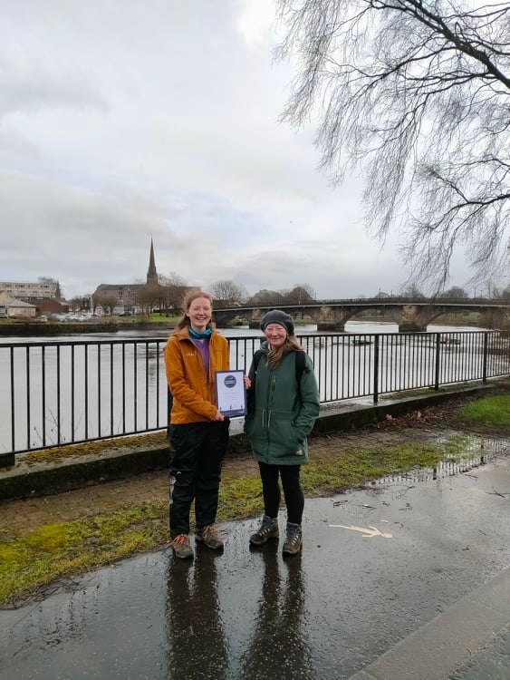 Cula with her award standing in front of the leven