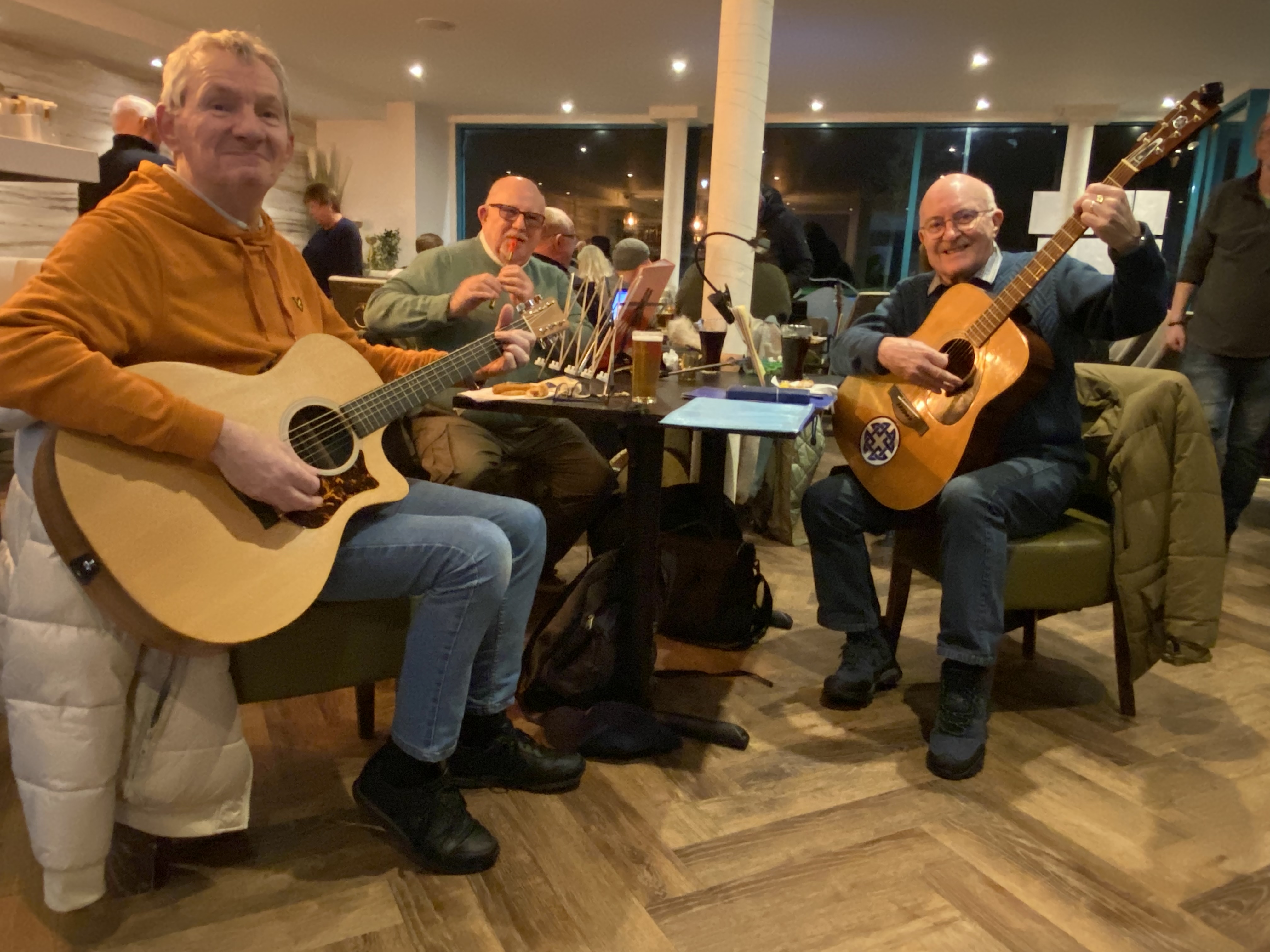 group of people sitting round table playing instruments