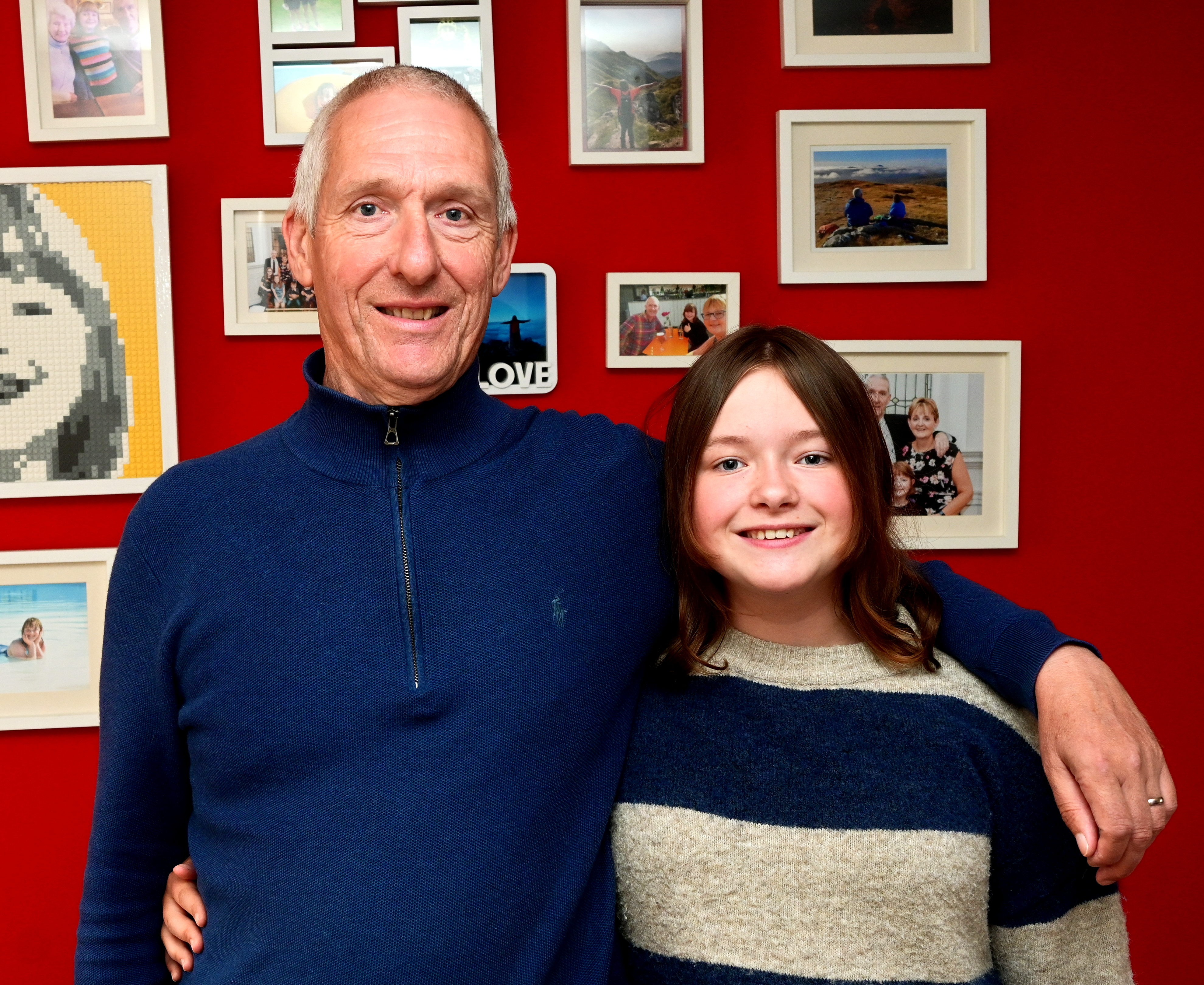 Close up of Lily and her dad Andrew standing side by side, arms around one another's shoulders