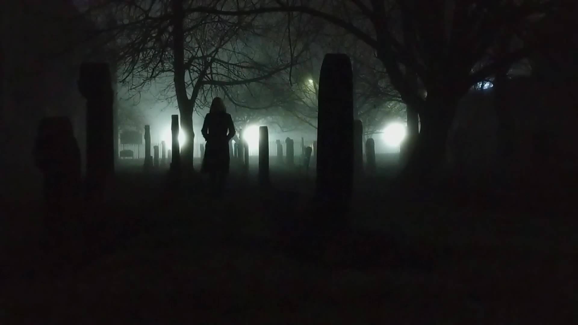 A creepy dark image of a shadowy figure in a graveyard.