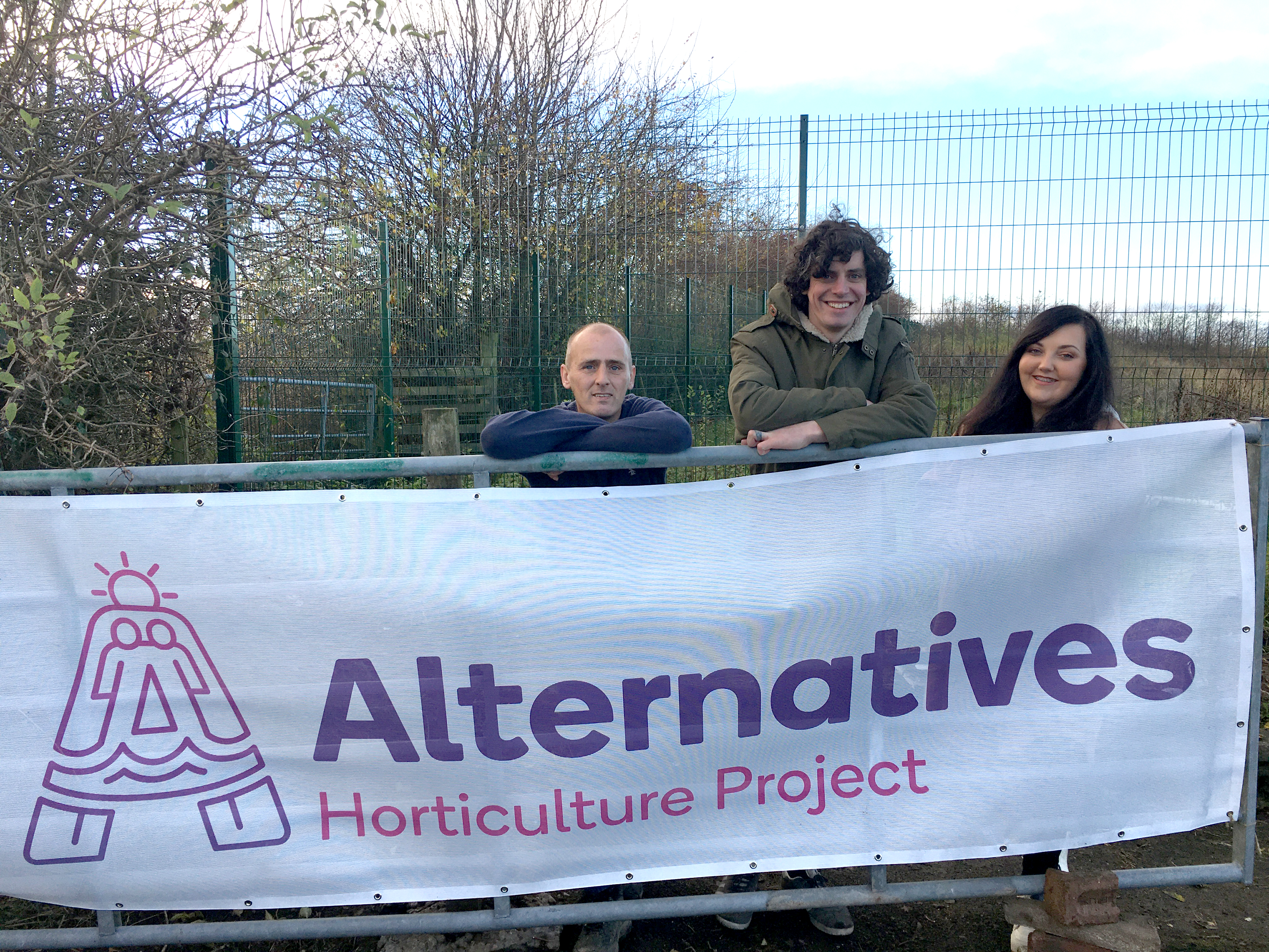 3 people holding up a large banner with "Alternatives. Horticulture Project" on it.
