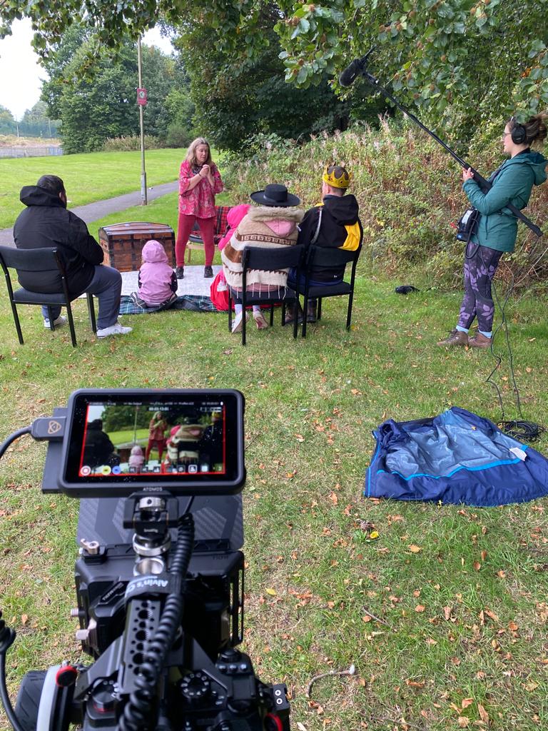 Filming the story being told to the kids in the park