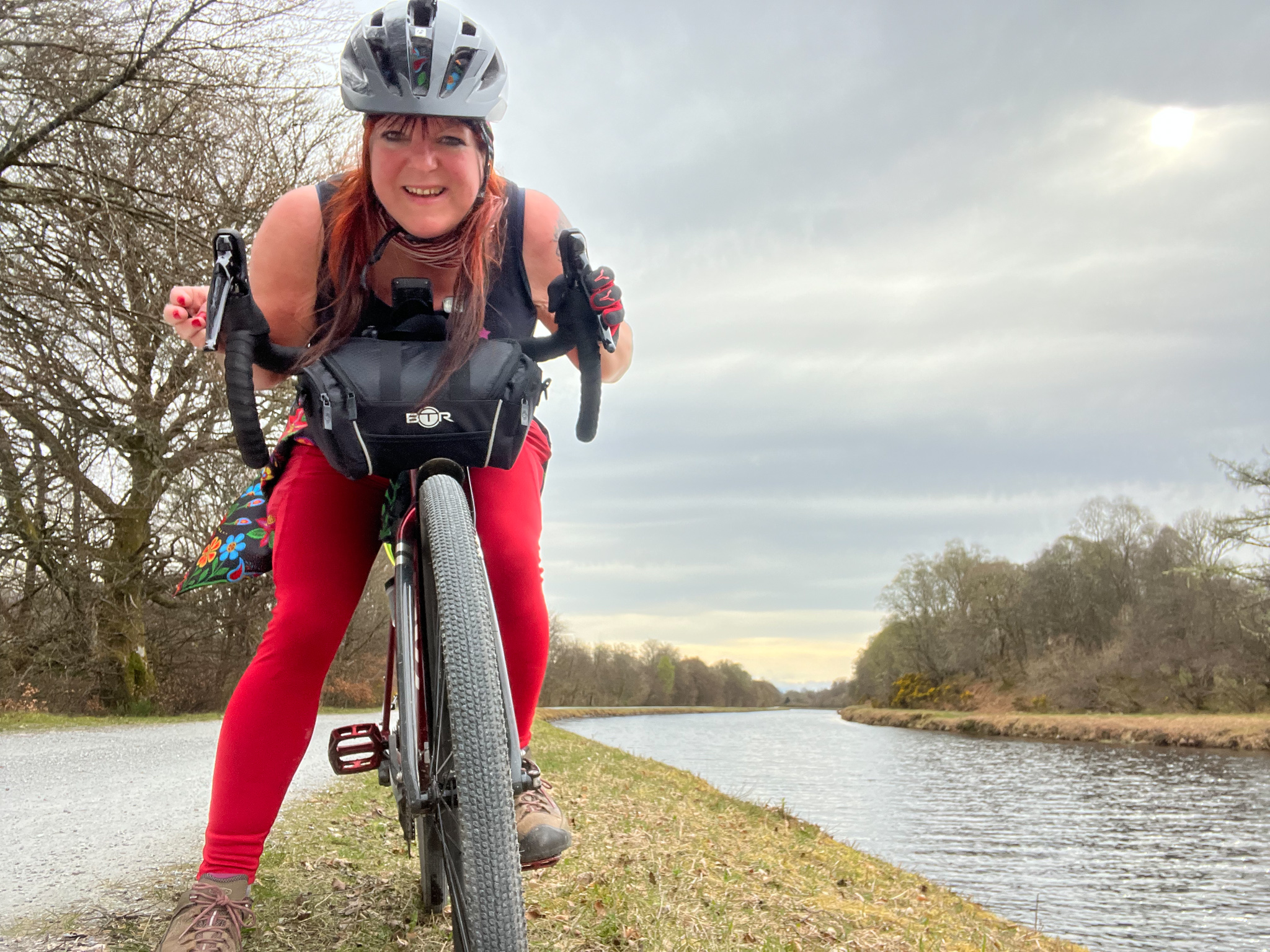 marie on her bike beside the leven