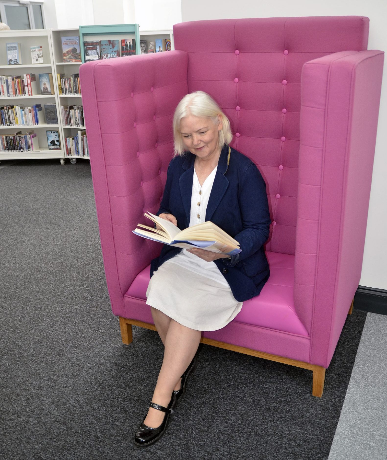 Librarian sitting in large oversized pink chair