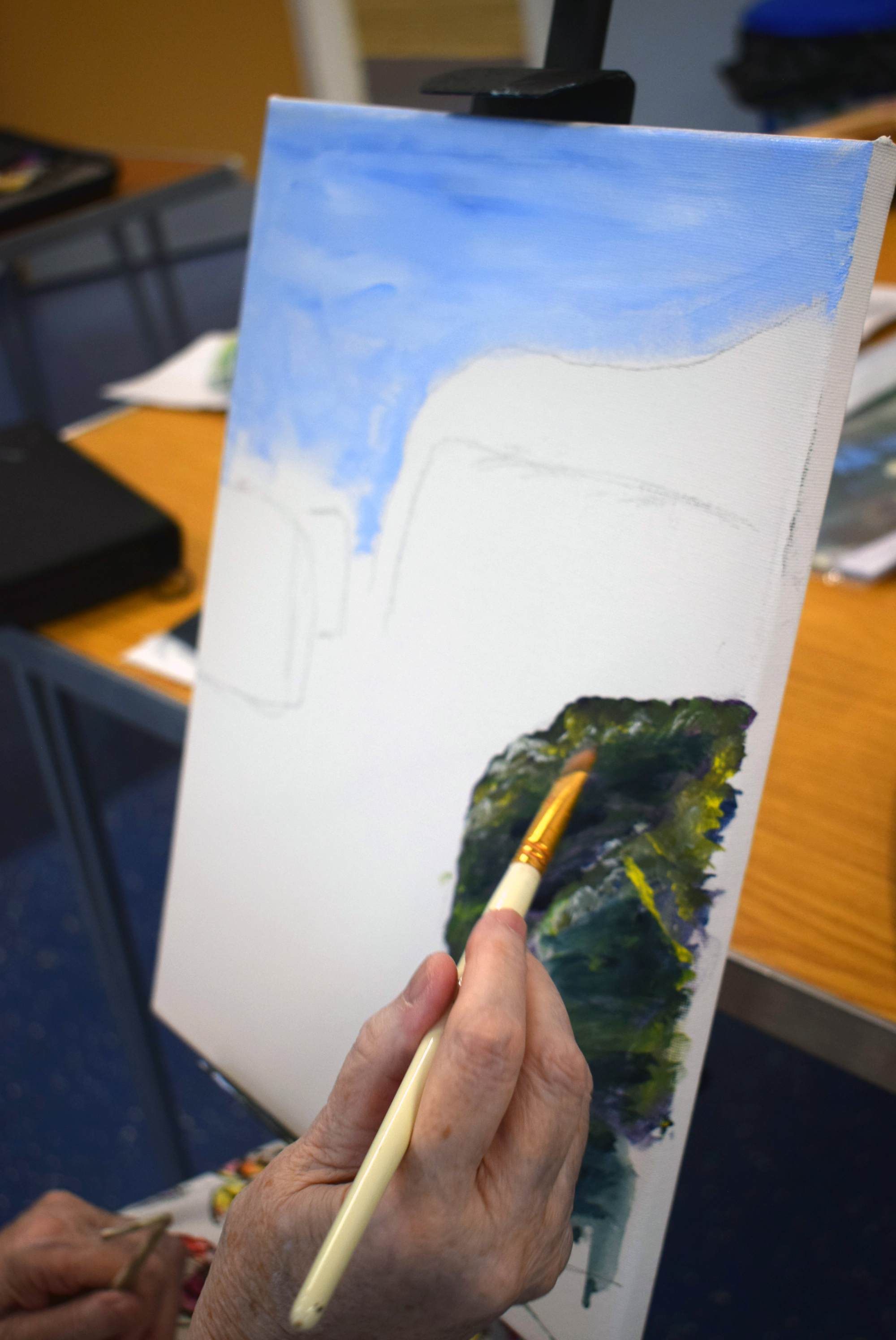 close of artist working on a painting