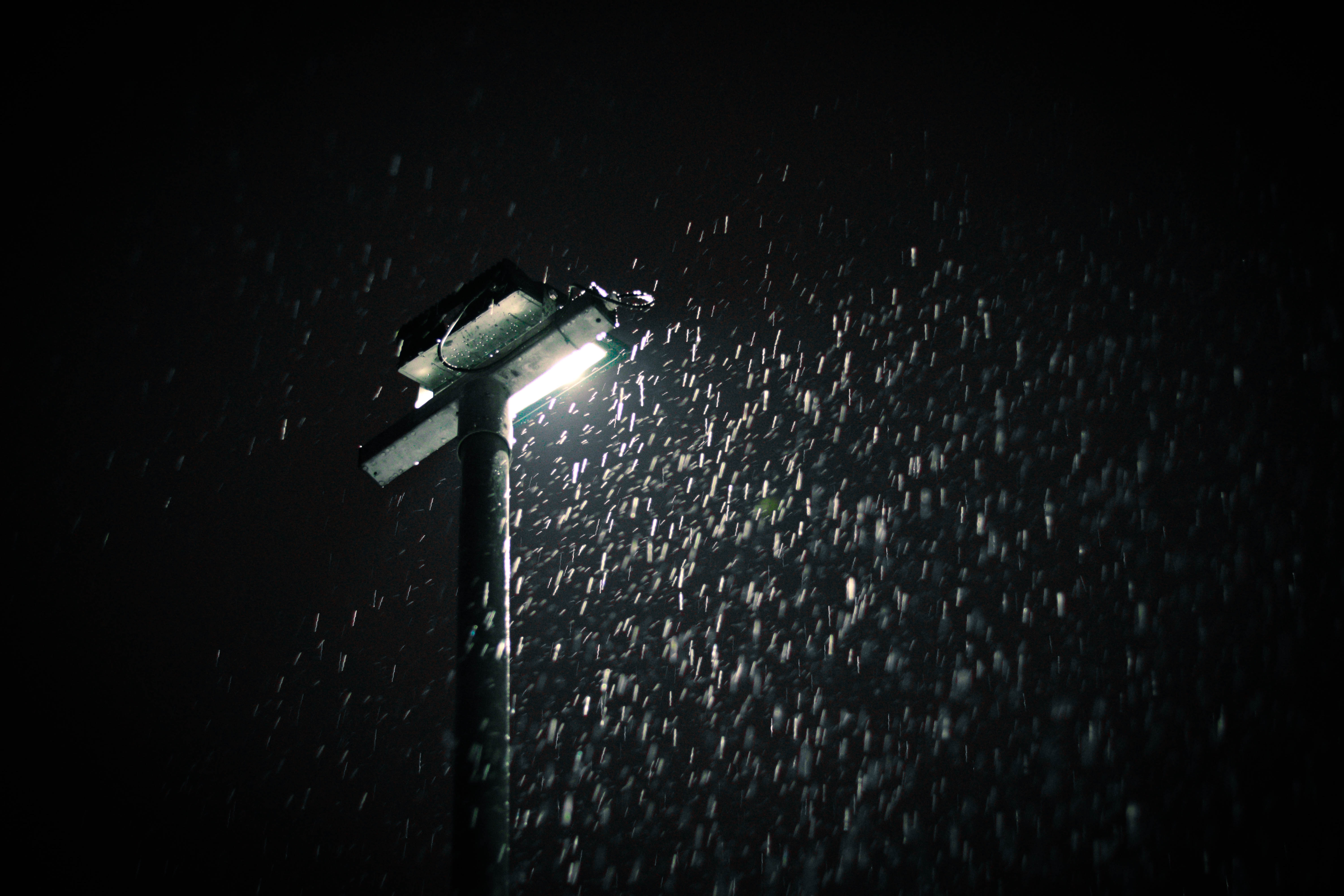 photo of streetlight illuminating falling raindrops