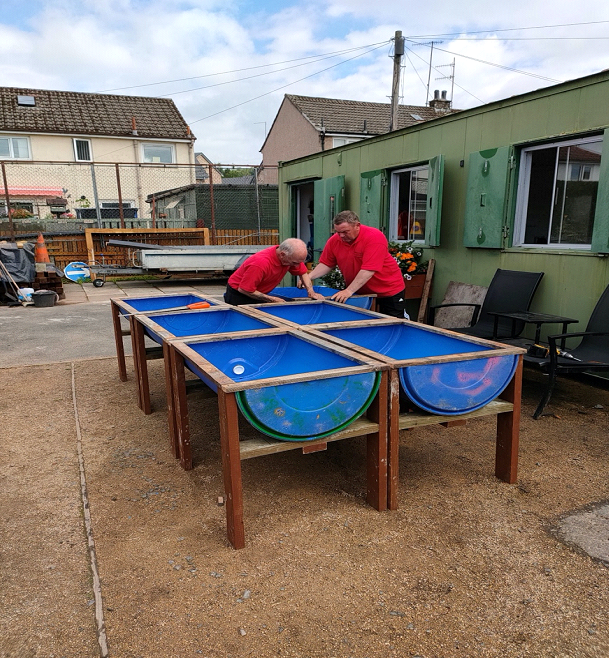 Two men constructing a raised planting bed.