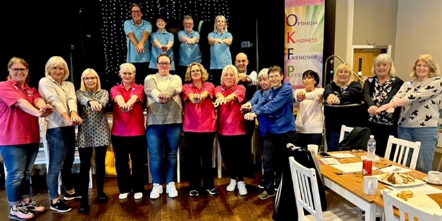 Group of people all standing posing with their arms out in front of them like they are providing CPR