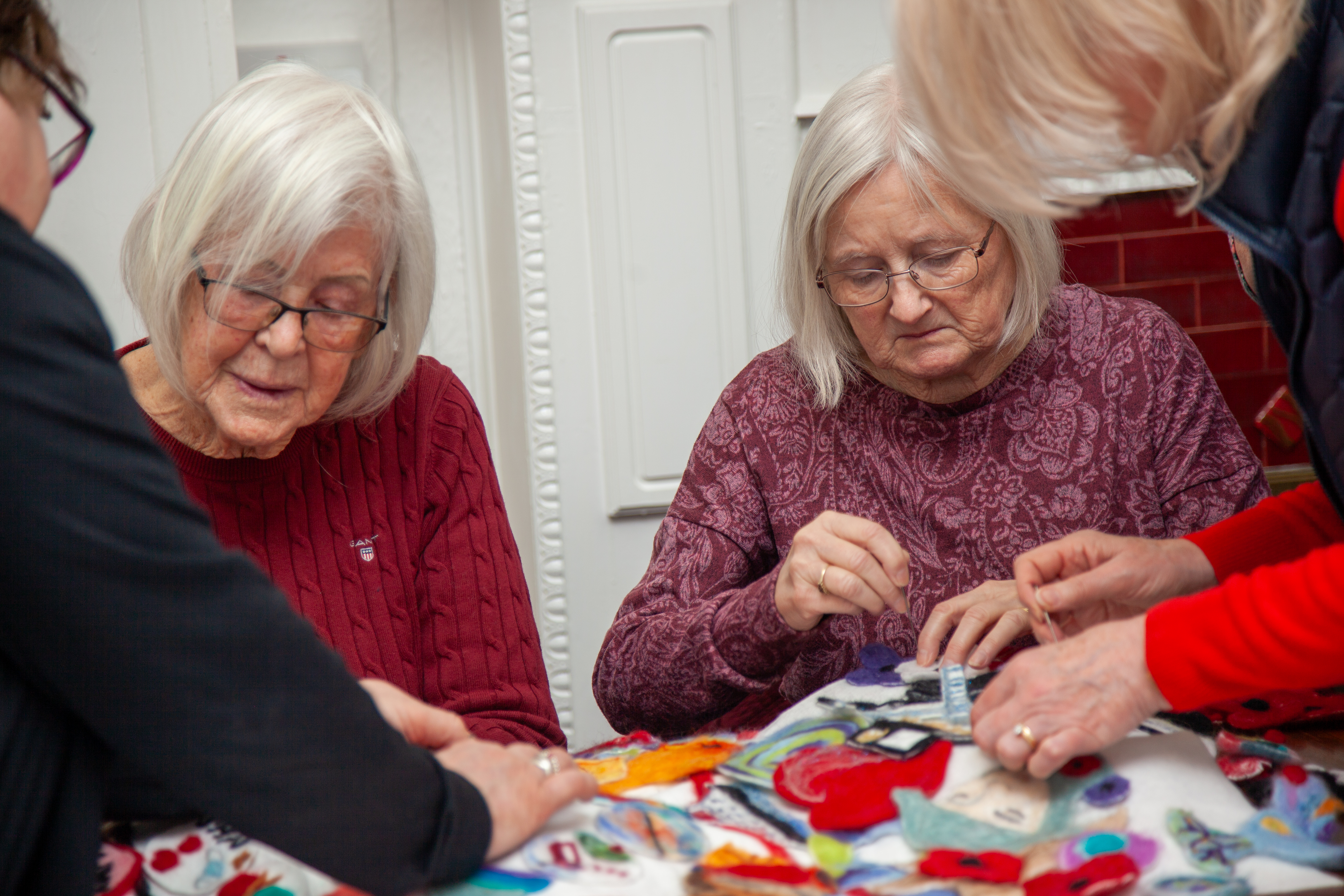four women working on their felting sitting at a table
