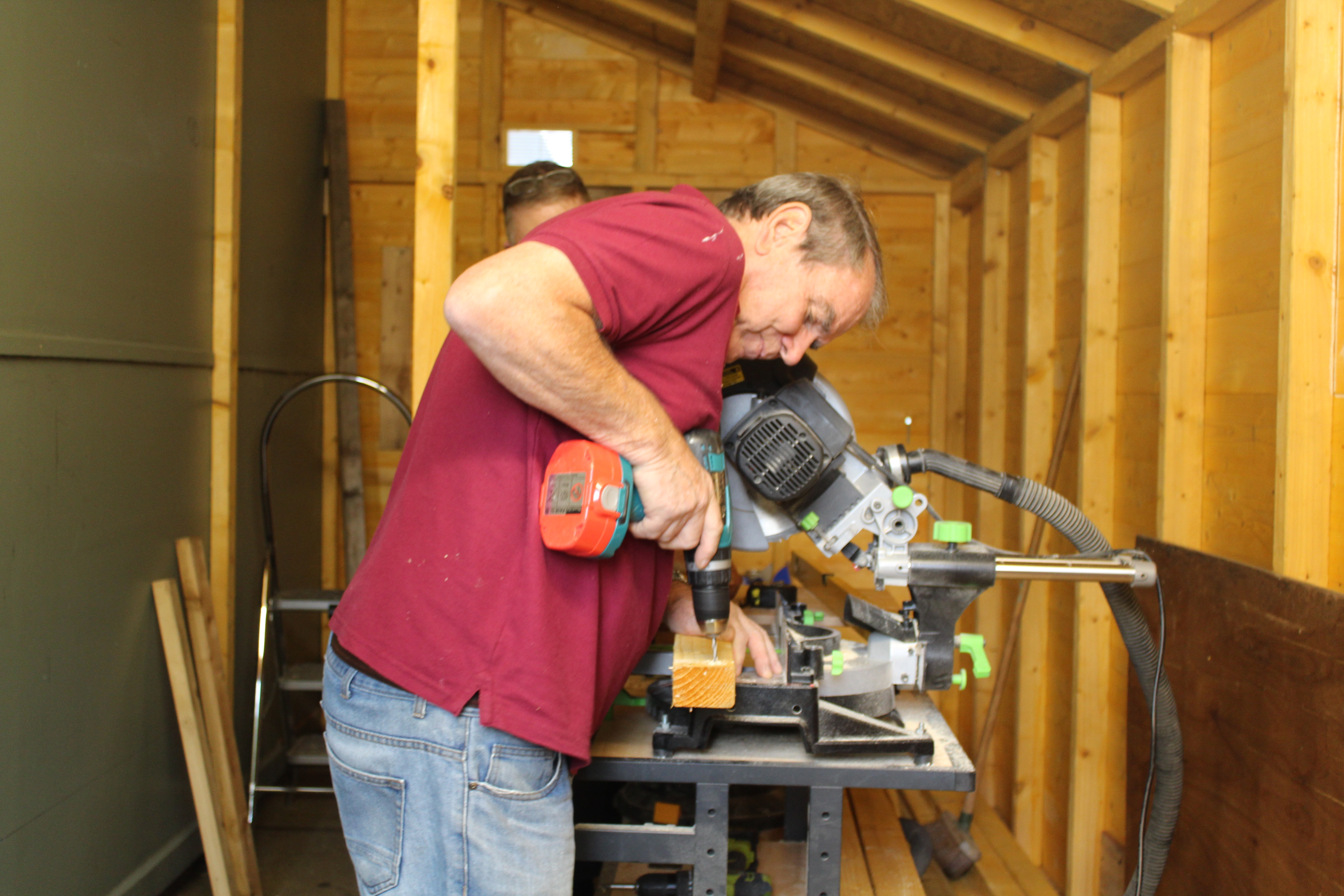 man drilling wood at workstation