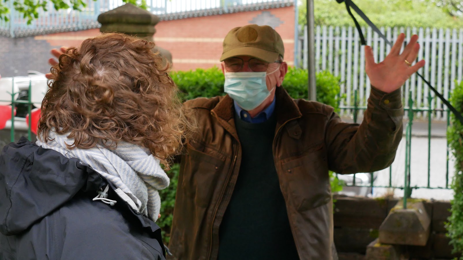 2 people greeting one another outside.