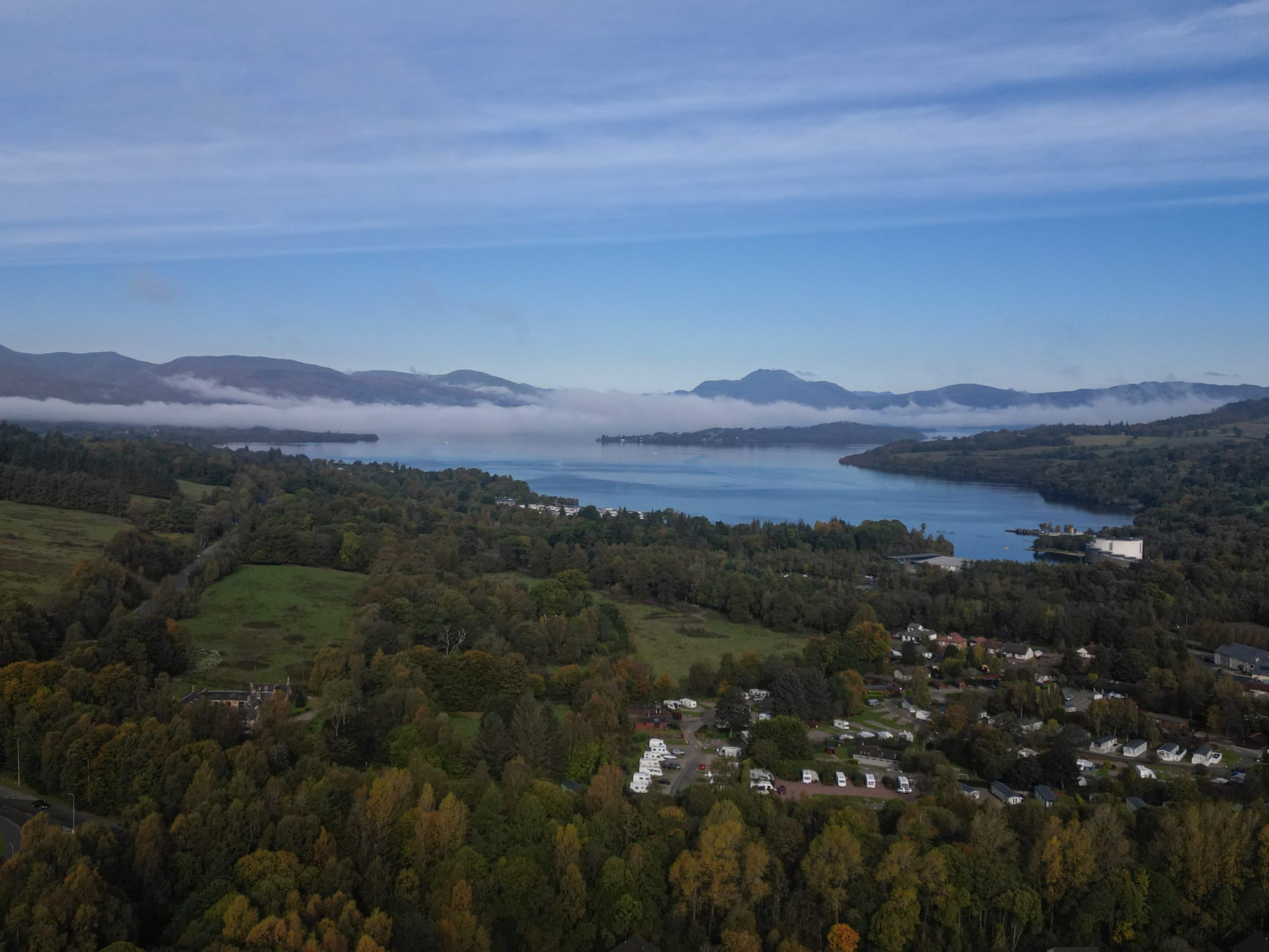 Drone shot of woodland in foreground and Loch Lomond behind