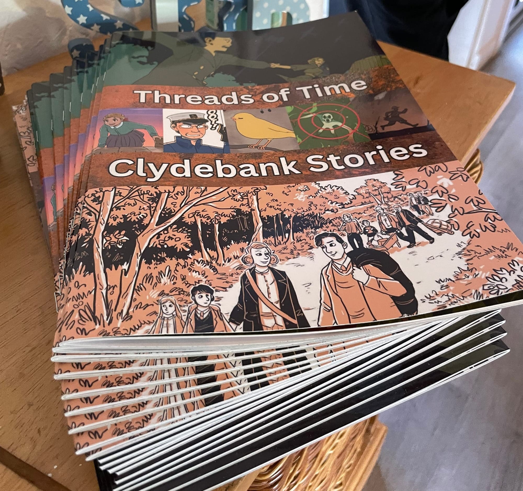 a pile of graphic novels fanned across a table top