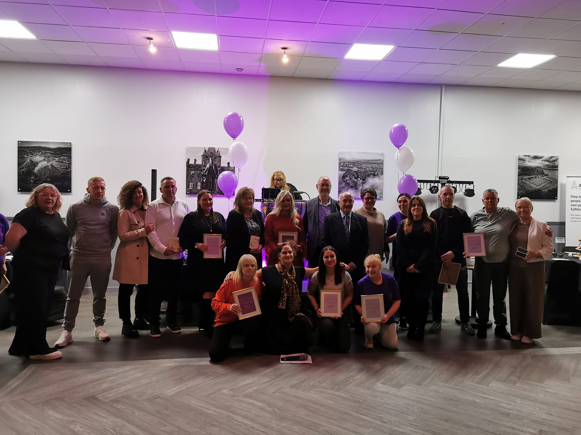 large group of people all holding up memorial framed gifts