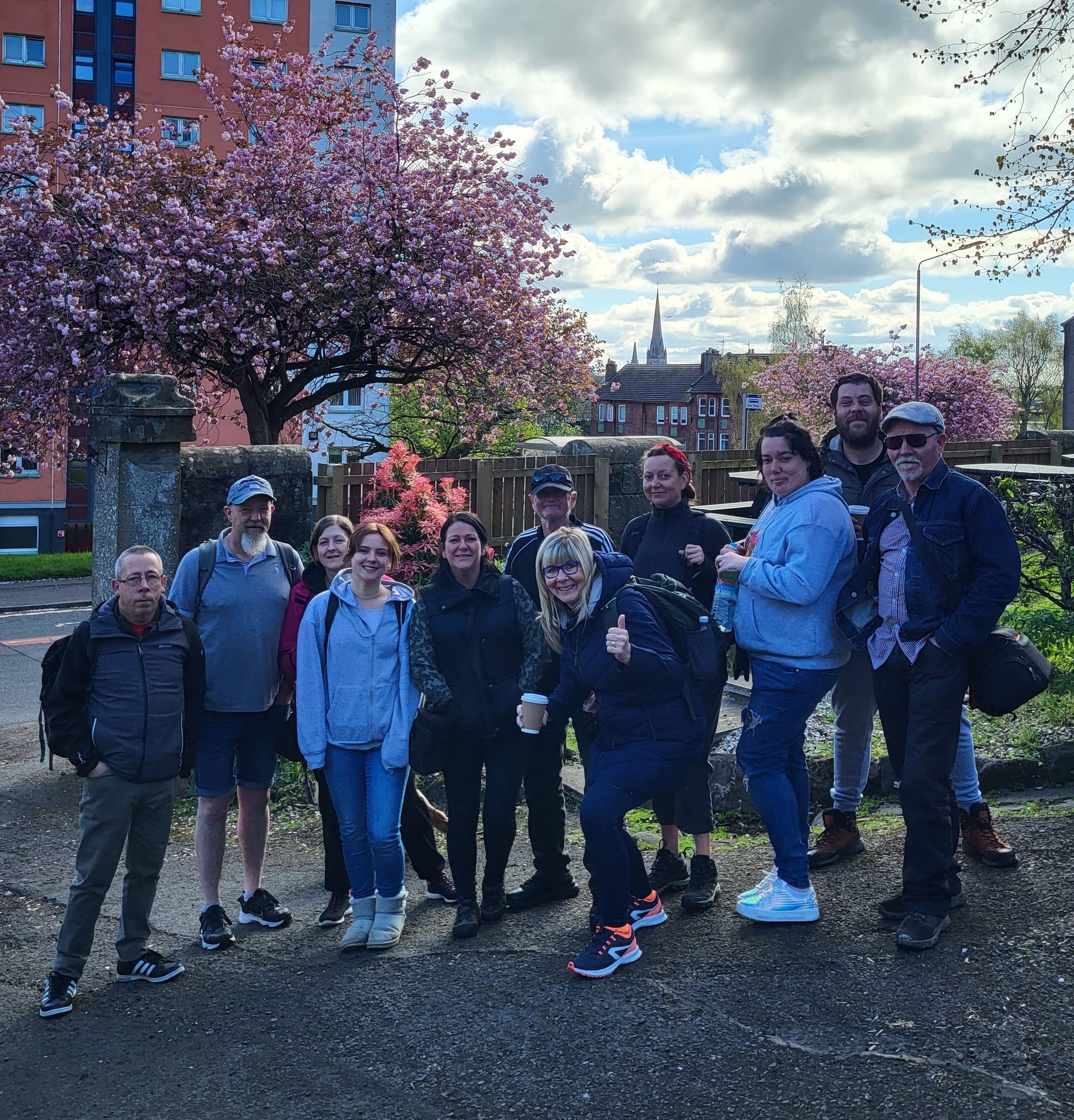 11 people standing together, posing for camera, getting ready to go out on a walk