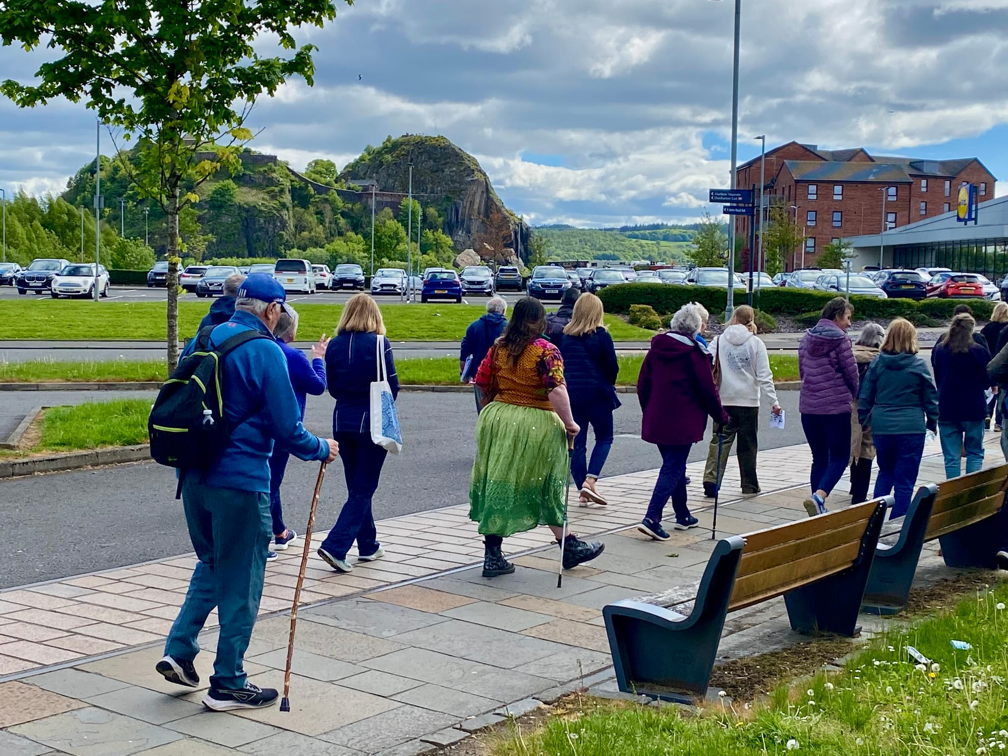 Group of people walking through Dumbarton with Dumbarton rock and castle in the background