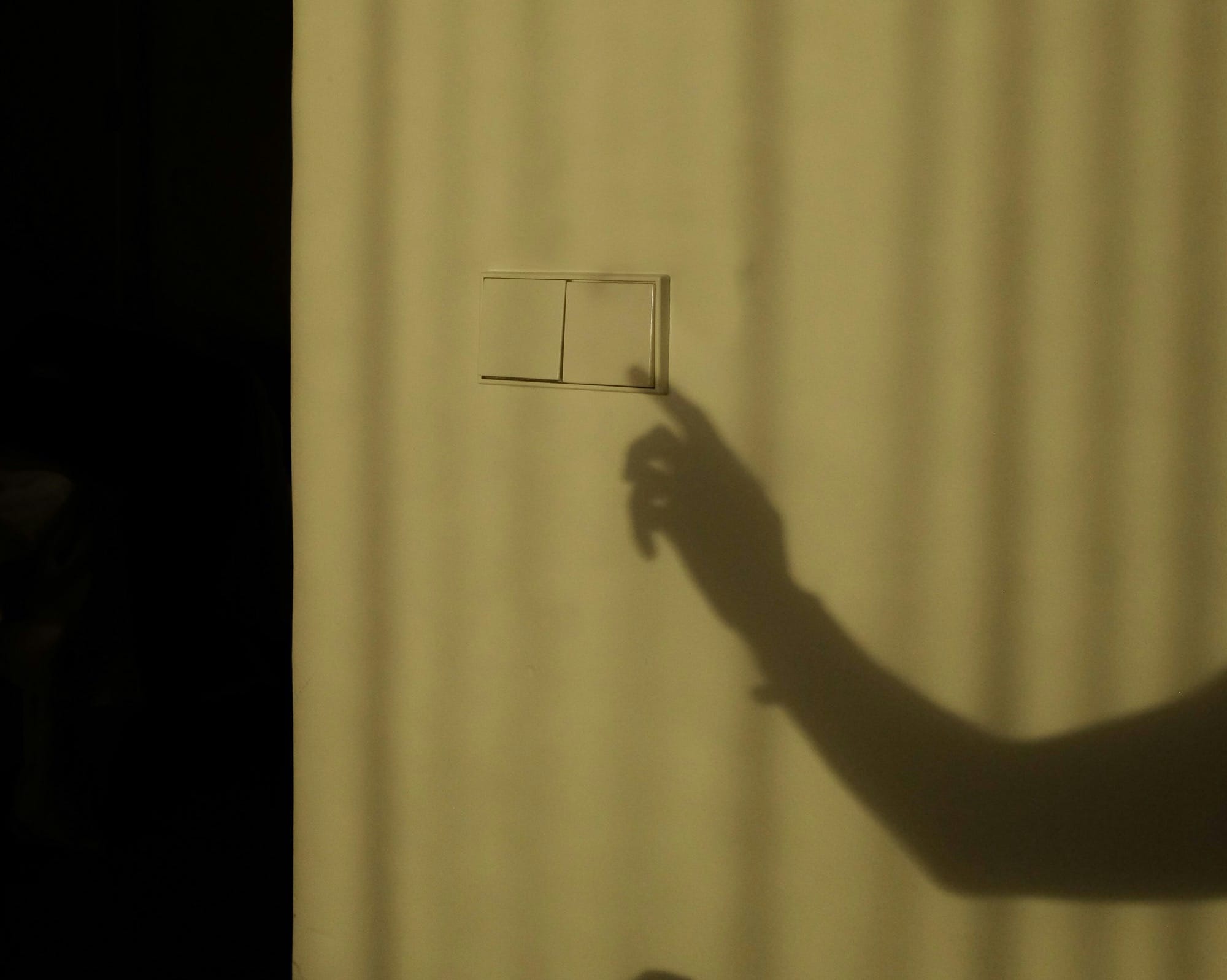 a shadow of a person holding a piece of paper